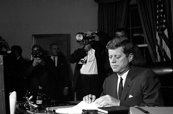 23 October 1962
Proclamation signing, Interdiction of the Delivery of Offensive Missiles to Cuba, 7:05PM.
[White spotting throughout negative.]

Please credit "Cecil Stoughton. White House Photographs. John F. Kennedy Presidential Library and Museum, Boston."