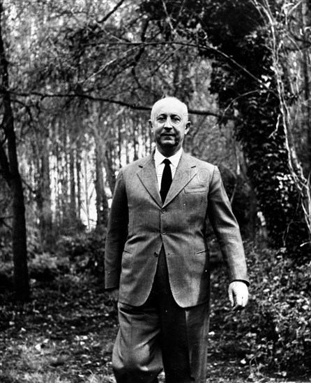 Fashion designer Christian Dior walking in the woods