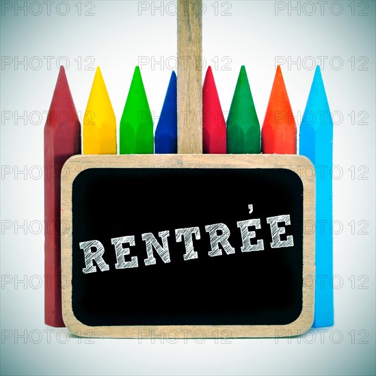 rentree, back to school written in french in a blackboard label and some crayons of different colors, with a retro effect