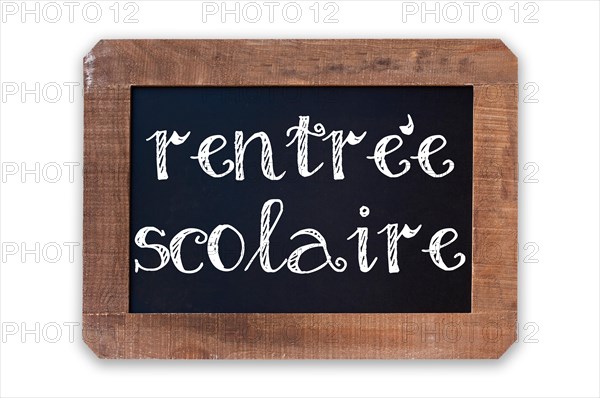 Rentree scolaire (meaning Back to school) written on a vintage blackboard with wooden frame isolated on white background