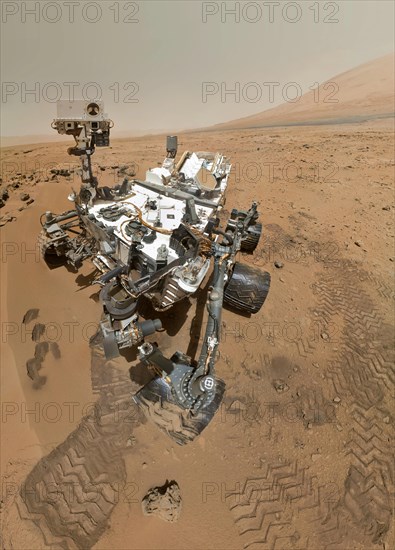 On Sol 84 (Oct. 31, 2012), NASA's Curiosity rover used the Mars Hand Lens Imager (MAHLI) to capture this set of 55 high-resolution images, which were stitched together to create this full-color self-portrait. The mosaic shows the rover at "Rocknest," the spot in Gale Crater where the mission's first scoop sampling took place. Four scoop scars can be seen in the regolith in front of the rover. The base of Gale Crater's 3-mile-high (5-kilometer) sedimentary mountain, Mount Sharp, rises on the right side of the frame. Mountains in the background to the left are the northern wall of Gale Crater.