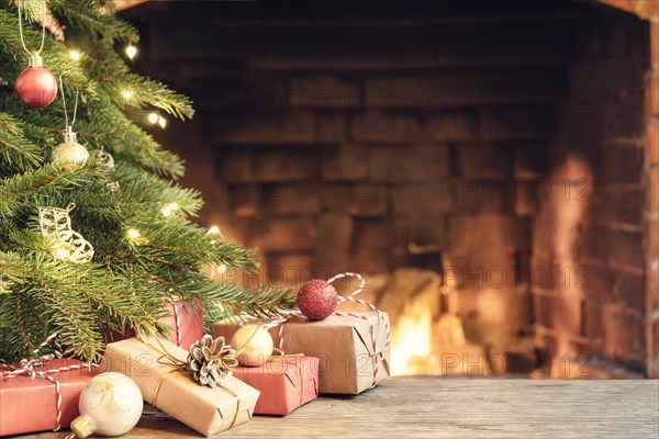 Gifts under the Christmas tree in the room with a fireplace on Christmas eve.