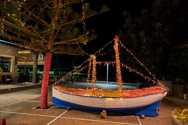 Wooden Christmas ship decorated at night. In the Greek tradition (especially in the islands) it is common to ornament a ship instead of a tree for Ch