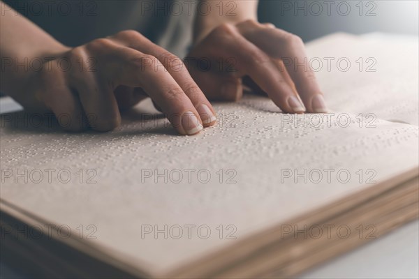 Blind man reads the text of a braille book.