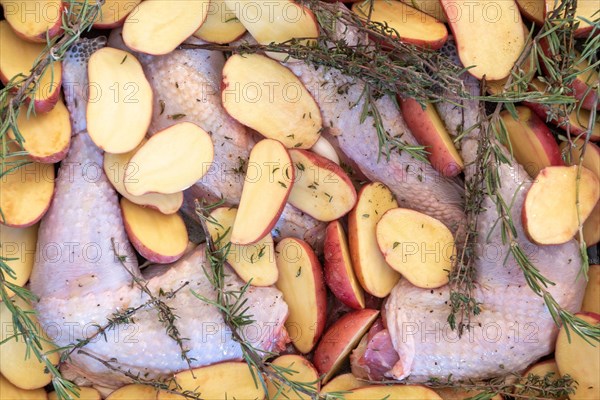 Food, preparation, black chicken, halved potatoes, rosemary, Christmas dinner.