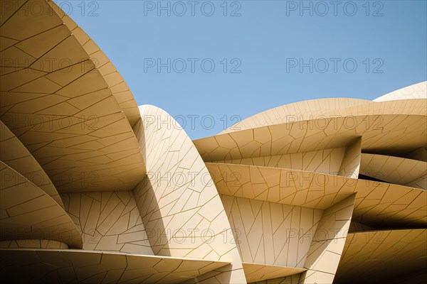 Modern contemporary architecture National Museum of Qatar by Jean Nouvel in Doha city with blue sky backgound