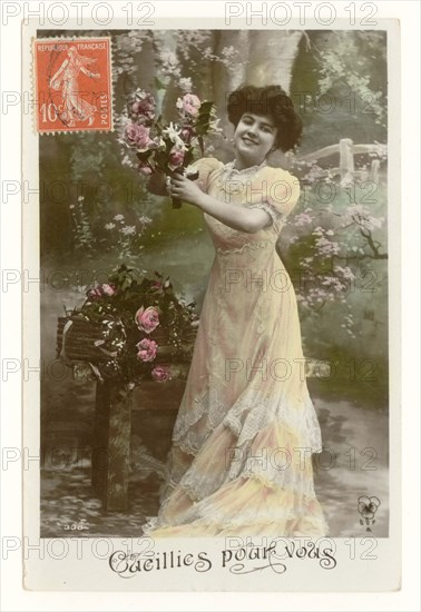 Early 1900's French sentimental tinted greetings postcard of a pretty woman in long flowing dress smiling and picking roses  - entitled "Picked for you", France, circa 1911