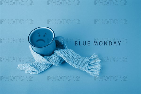 Blue cup with scarfcoffee on blue background. Blue monday concept