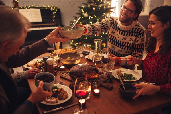 Family having a Christmas eve dinner together inside their home. European family enjoying dinner at Christmas eve.