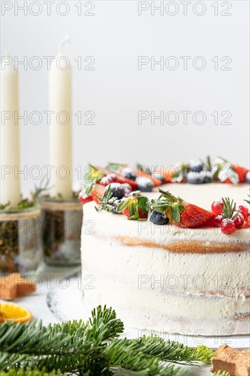 Homemade birthday cake for New year and Christmas. Christmas tree branches for decorating the Christmas table.