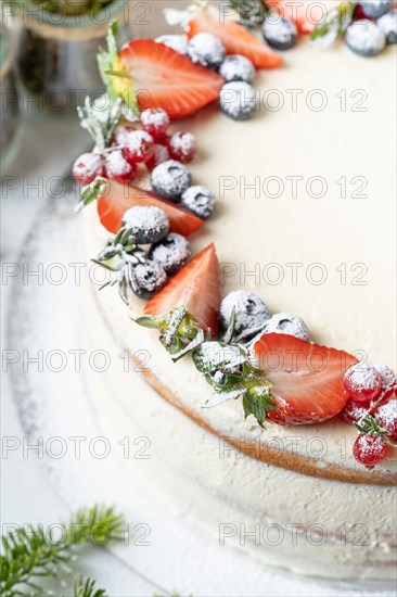 Homemade birthday cake for New year and Christmas. Christmas tree branches for decorating the Christmas table.