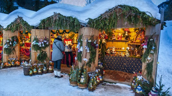 Romantic christmas market in Bavaria with illuminated wooden shops in snow