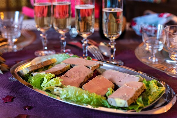 Traditional french gourmet foie gras platter served with champagne glasses for Christmas or New Year's Eve dinner.