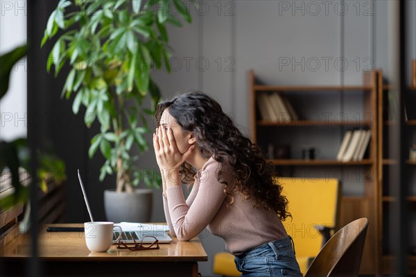 Disappointed female office worker struggling through task, tired overworked female employee