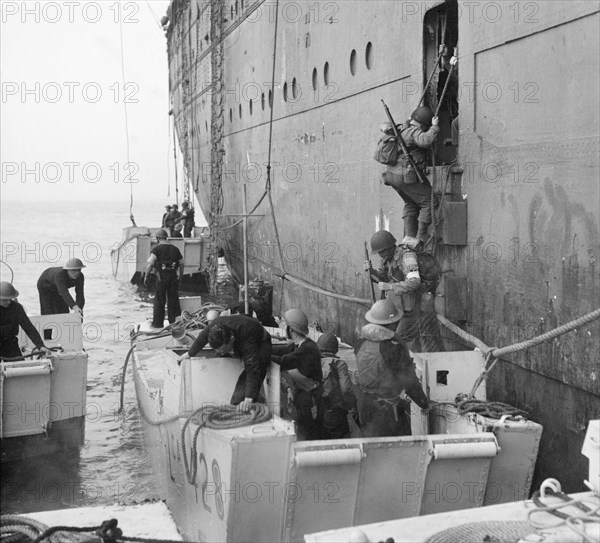 American troops climb into assault landing craft from the liner REINA DEL PACIFICO during Operation 'Torch', the Allied landings in North Africa, November 1942. American troops manning their landing craft assault from a doorway in the side of the liner REINA DEL PACIFICO. Two of the landing craft are numbered LCA 428 and LCA 447.