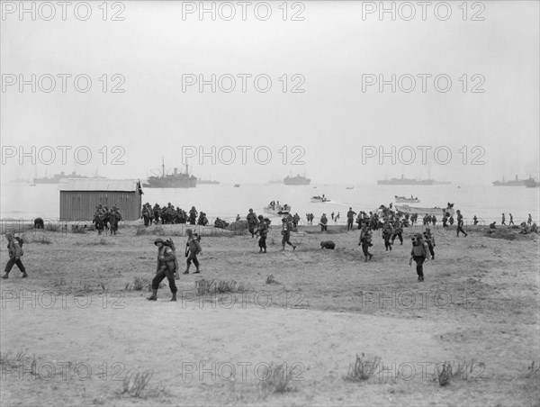 The Royal Navy during the Second World War- Operation Torch, North Africa, November 1942 American troops making their way inland after landing at Arzeu. Several small landing craft can be seen in the foreground whilst in the distance can be seen some of the troopships that helped transport the men.