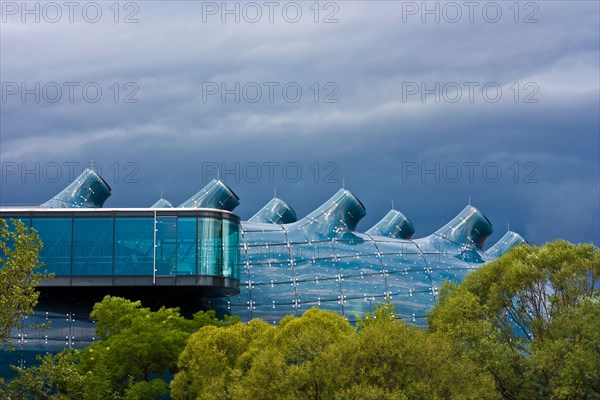 Kunsthaus Graz, a huge bluish bubble called "friendly alien" is the art gallery from Graz, Styria, Austria. Dark clouds before r