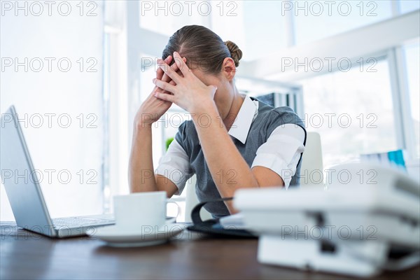 Depressed businesswoman with hands on head