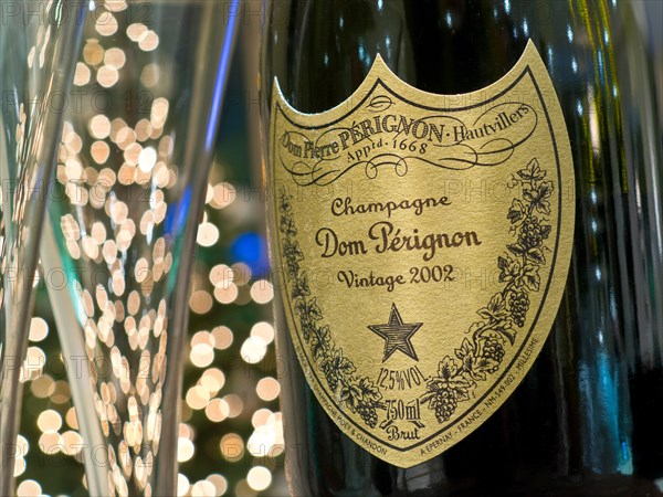 Dom Perignon vintage 2002 luxury champagne and glasses with sparkling lights in background