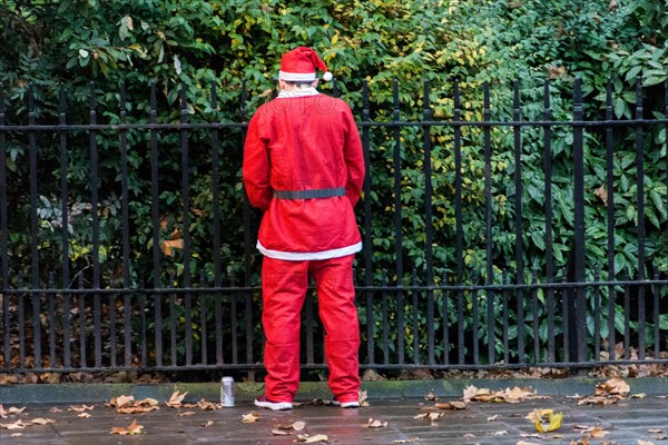 Santa takes a toilet break on the streets of London. Santacon is a non-religious Christmas parade that normally takes place in London one Saturday each December.