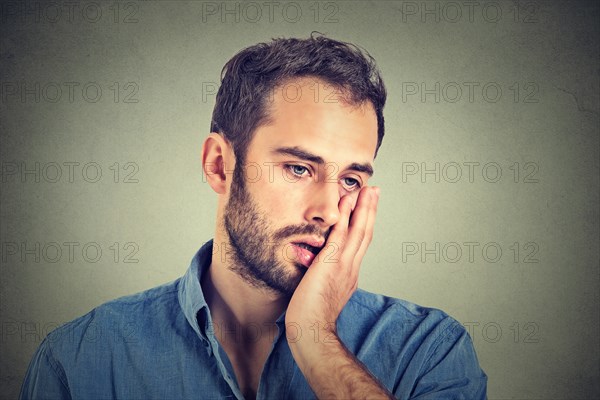 portrait of desperate unhappy man isolated on gray wall background