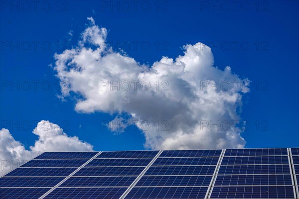 Solar panels on roof of building, with blue sky and white clouds, Mont-Dauphin, France