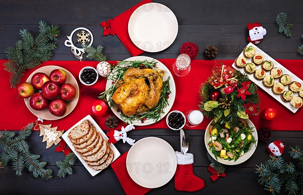 Baked turkey. Christmas dinner. The Christmas table is served with a turkey, decorated with bright tinsel and candles. Fried chicken, table.  Family d