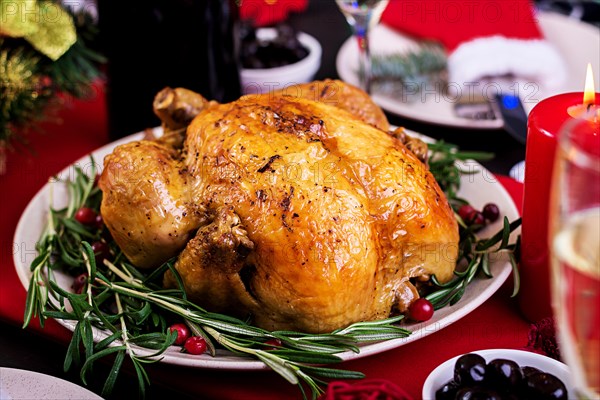 Baked turkey. Christmas dinner. The Christmas table is served with a turkey, decorated with bright tinsel and candles. Fried chicken, table.  Family d