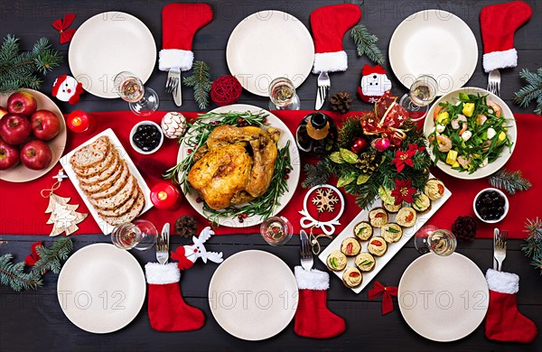 Baked turkey. Christmas dinner. The Christmas table is served with a turkey, decorated with bright tinsel and candles. Fried chicken, table.  Family d