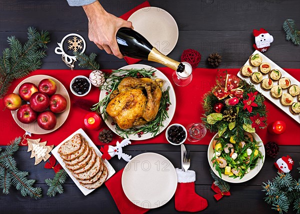 Baked turkey. Christmas dinner. The Christmas table is served with a turkey, decorated with bright tinsel and candles. Fried chicken, table.  Family d