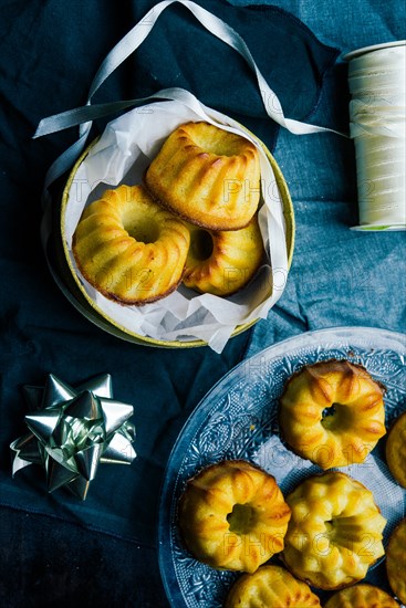 Christmas mini bundt cake and decoration on a board with christmas decoration, a golden package and scissors,top view, flat lay copyspace.