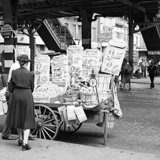 1930s 1940s 59TH STREET THIRD AVENUE UNDER EL STATION WOMAN SHOPPING FOR VEGETABLES AT STREET VENDOR PUSH CART NEW YORK CITY USA - q47436 CPC001 HARS B&W VENDOR CUSTOMER SERVICE CHOICE EXTERIOR AT OPPORTUNITY NYC OCCUPATIONS CONCEPTUAL NEW YORK CITIES CONSUMER NEW YORK CITY PUSH CART COMMERCE FRUITS MID-ADULT MID-ADULT WOMAN THIRD AVENUE 59TH STREET BLACK AND WHITE CAUCASIAN ETHNICITY OLD FASHIONED
