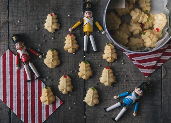 Overhead view of figurines with cookies on wooden table during Christmas