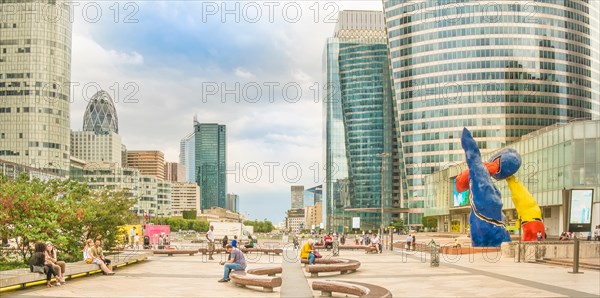 people relaxing on the promenade of la defense