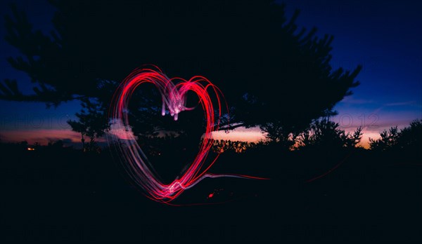 Passionate token of love as a surreal, stylish and cool heart-shaped fire ring outdoors at night. pleasure and passion.