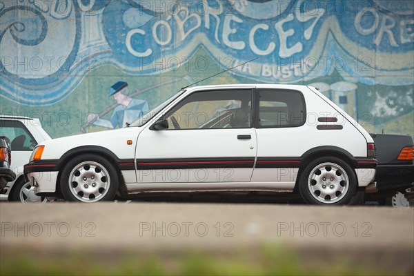 Cobreces, Spain - August 14, 2021: Car show in Cobreces. Original white Peugeot 205 GTI side face. The Peugeot 205 is a car produced by the French man