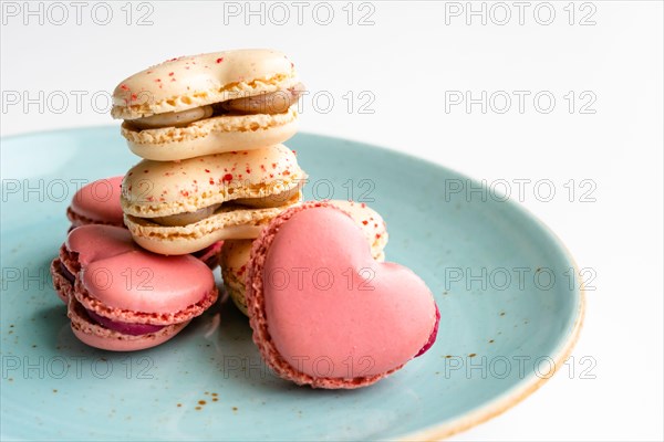 Macarons cakes in a shape of a heart. Small French cakes for Valentines Day. Sweet and colorful french macaroons.