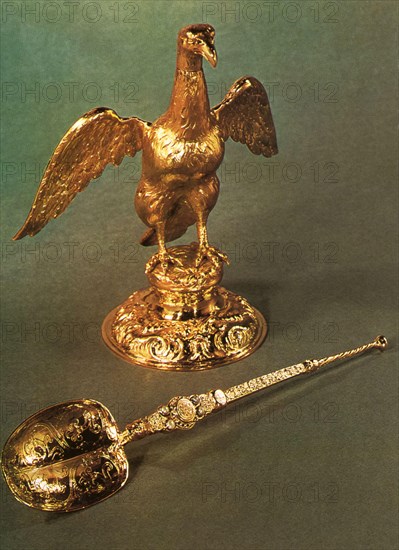 The Ampulla and Coronation Spoon. When a monarch is anointed, the Dean of Westminster first pours holy anointing oil from an ampulla into a spoon. The original ampulla was a small stone phial, sometimes worn around the neck as a pendant by kings, and otherwise kept inside an eagle-shaped golden reliquary. It is unclear why, after the Restoration, the vessel itself came to be reinterpreted as an eagle standing on a domed base. The Coronation Spoon, dates from the late 12th century and is silver-gilt and set with four pearls, which were added in the 17th century.
