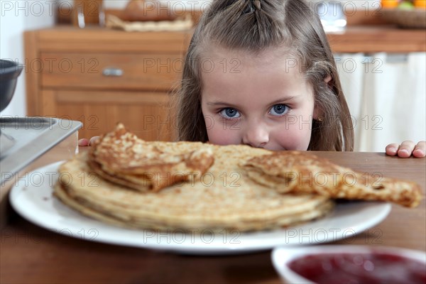 Greedy girl looking at pancakes