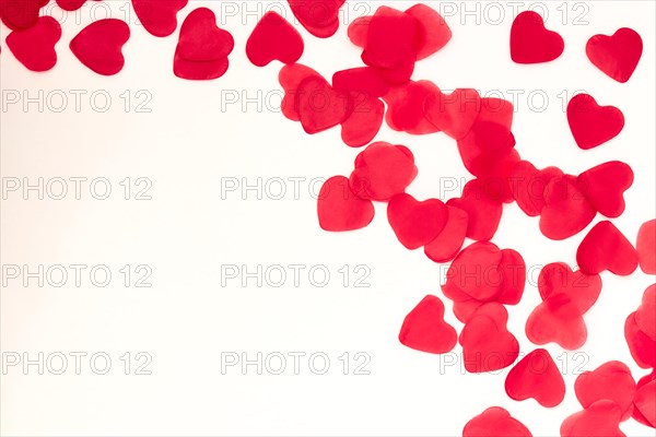 scattered red hearts on a white background. Excellent background to the day of Saint Valentine.