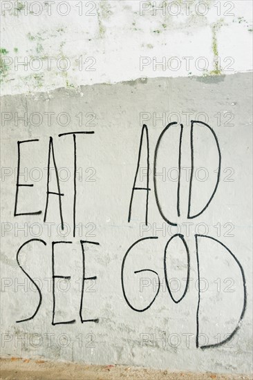 text-graffito saying "eat acid, see god" ,