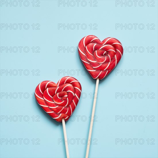 Valentine's card. Two lollipops candy as heart on blue background. Funny concept.