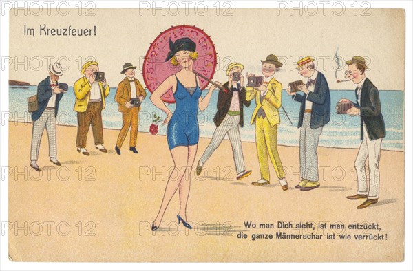 German historical postcard: A young woman in a swimsuit with an umbrella and a rose flower poses for numerous men with cameras. Germany, the 1900s