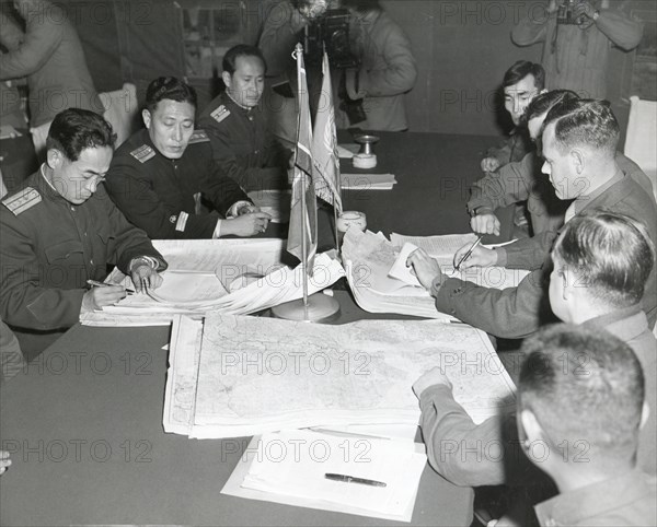 Panmunjom, Korea - Col. James C. Murray, Jr., USMC (rt) and Col Chang Chun San, of the North Korean Communist Army (left) initial maps showing the North and South boundaries of the Demarcation Zone, during cease fire talks.