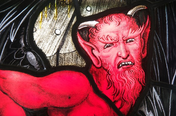 Portrait representing The Devil, in stained glass. Detail of a window in Saint Andrew’s Church in the Dorset village of West Stafford. England. UK.