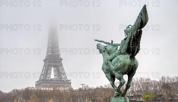 Eiffel Tower and Bir-hakeim statue on a misty day