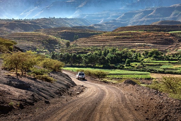 ETHIOPIA, LALIBELA, 4 wheel drive car on its way through a spectecular mountain scenery on a gravel road between  Mekelle and Lalibela