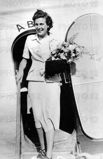 1937 , STOCKHOLM , SWEDEN : The german  Nazi  movie director and actress  LENI RIEFENSTAHL  ( 1902 - 2003 ) , friend of  ADOLF  HITLER  , arrival in Stockholm by air from Copenhagen , like a official representant of the german  Nazi Reich to present her film " Olympia " , shooting of last Summer Olympic Games in Berlin 1936 . - NAZI - NAZISMO - NAZISTA - WW2 - WWII - SECONDA GUERRA MONDIALE - DONNA REGISTA - CINEMA - FILM  - smile - sorriso  - orchidea - aeroplano - aeroporto - airport - flowers - fiori - fiore - borsetta - borsa - handbag - SVEZIA - Stoccolma ---  Archivio GBB