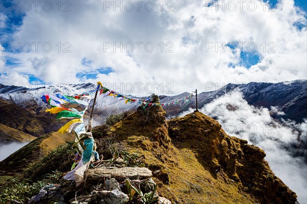 Prayer flags atop the Thombu La pass blowing in the breeze on a sunny, day in Bhutan