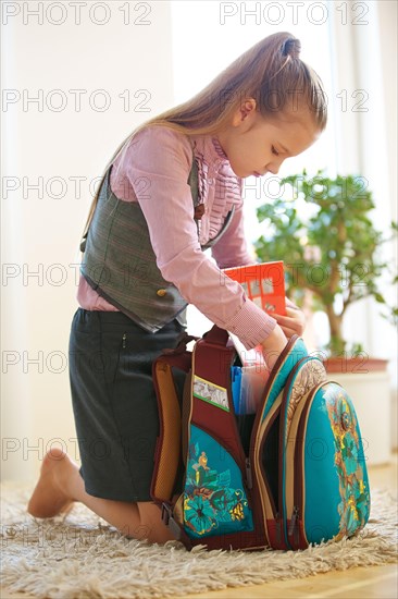 Child packs the satchel for school at home